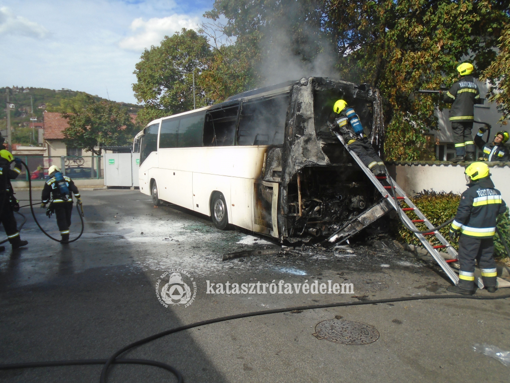 teljesen kiégett a busz hátulja, körülötte a tűzoltók oltanak