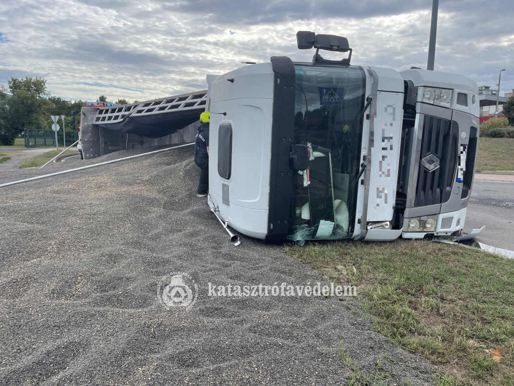 oldalára borult kamion, mellette a kiborult rakomány