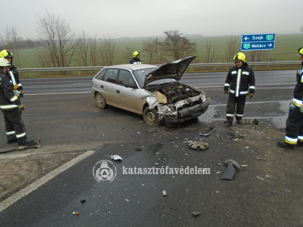 a balesetben érintett személyautó, körülötte tűzoltók