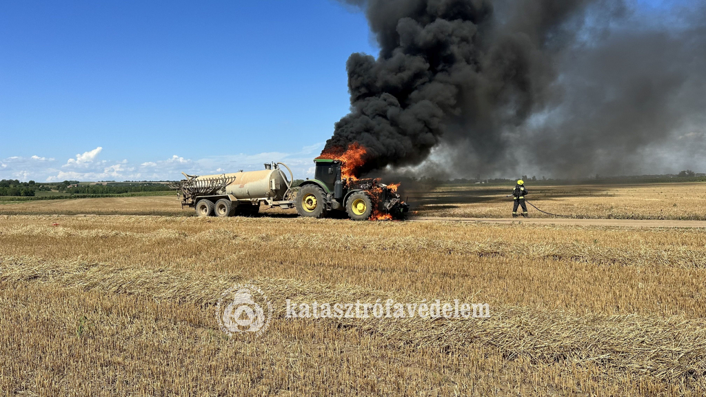 lángoló traktor, előtte tűzoltó