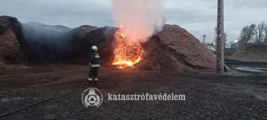 tűzoltó oltja az izzó kupacot