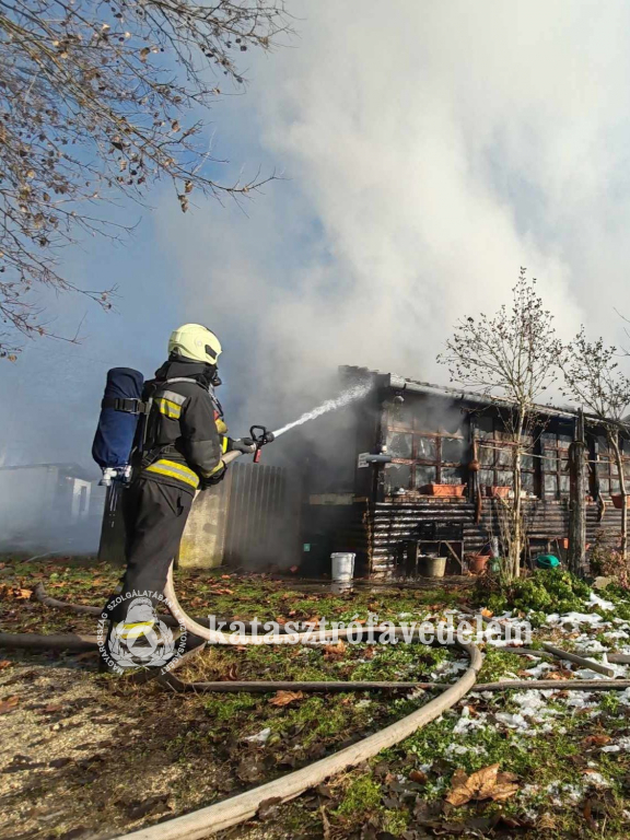 tűzoltó oltja a házat
