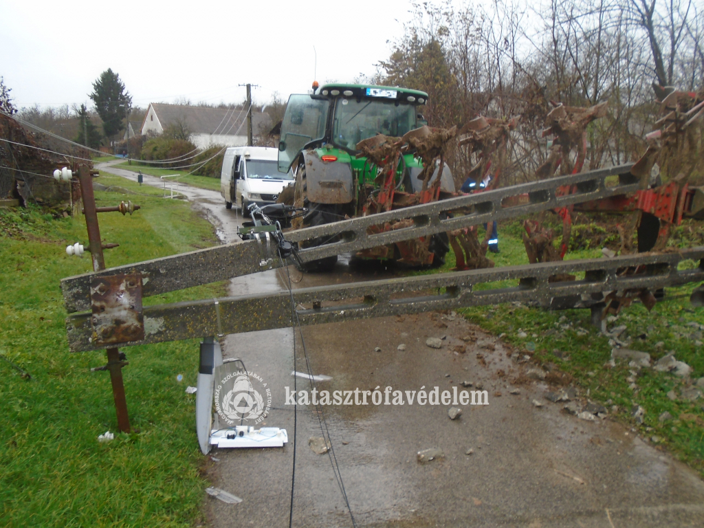 traktor, előtte kidőlt beton villanyoszlop