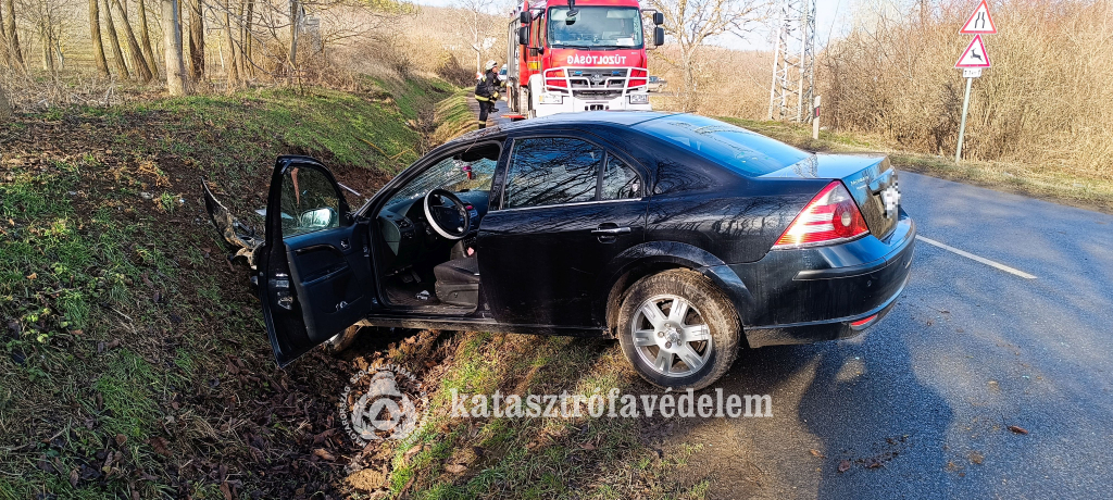 árokba hajtott személyautó, mögötte tűzoltóautó, tűzoltó