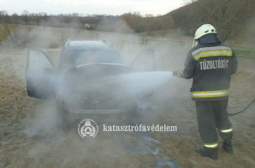 tűzoltó oltja az autót