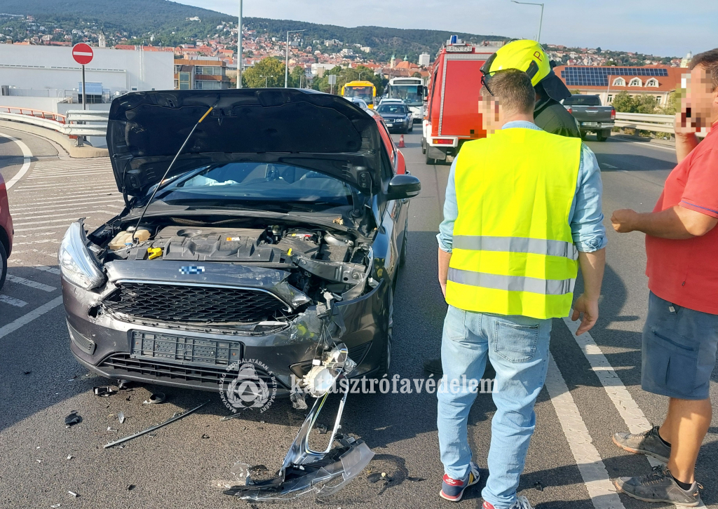 személyautó, tűzoltó, civilek a hídon