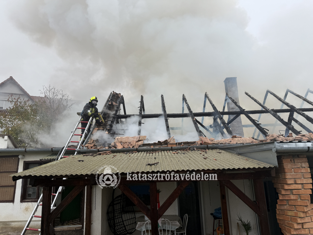 tűzoltó oltja a tetőt