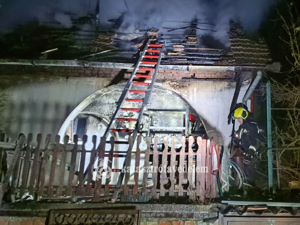 tűzoltó a kiégett ház teraszán