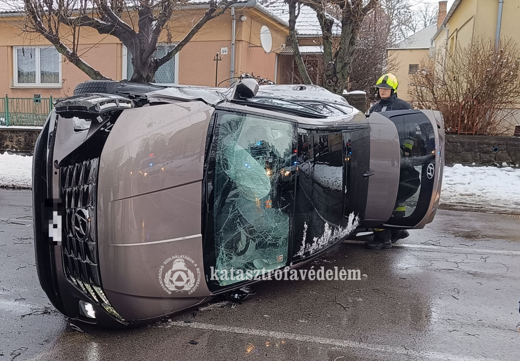 oldalára borult személyautó, tűzoltó