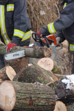 Tűzifát darabolnak fel a tűzoltók.