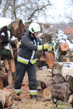 Tűzifát darabolnak fel a tűzoltók.