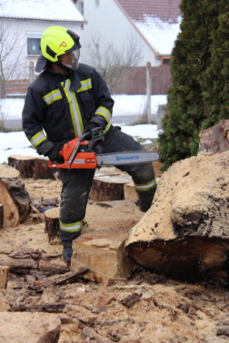 Tűzifát darabolnak fel a tűzoltók.