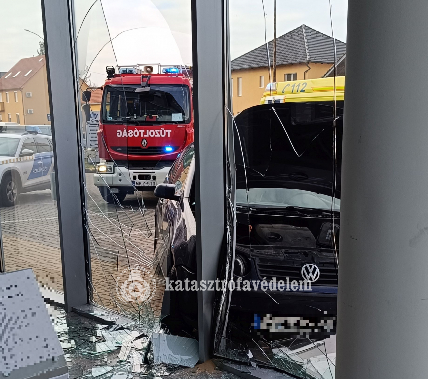 kirakatnak hajtott autó az épület belsejéből fotózva