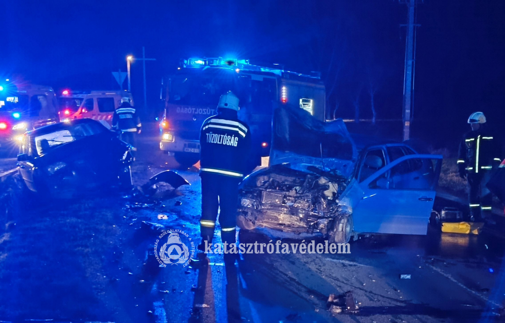 a baleset helyszíne - összetört személyautók, mellettük tűzoltó- és mentőautó, tűzoltók