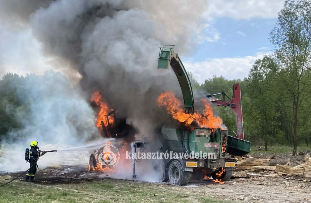 tűzoltó oltja a lángoló járművet