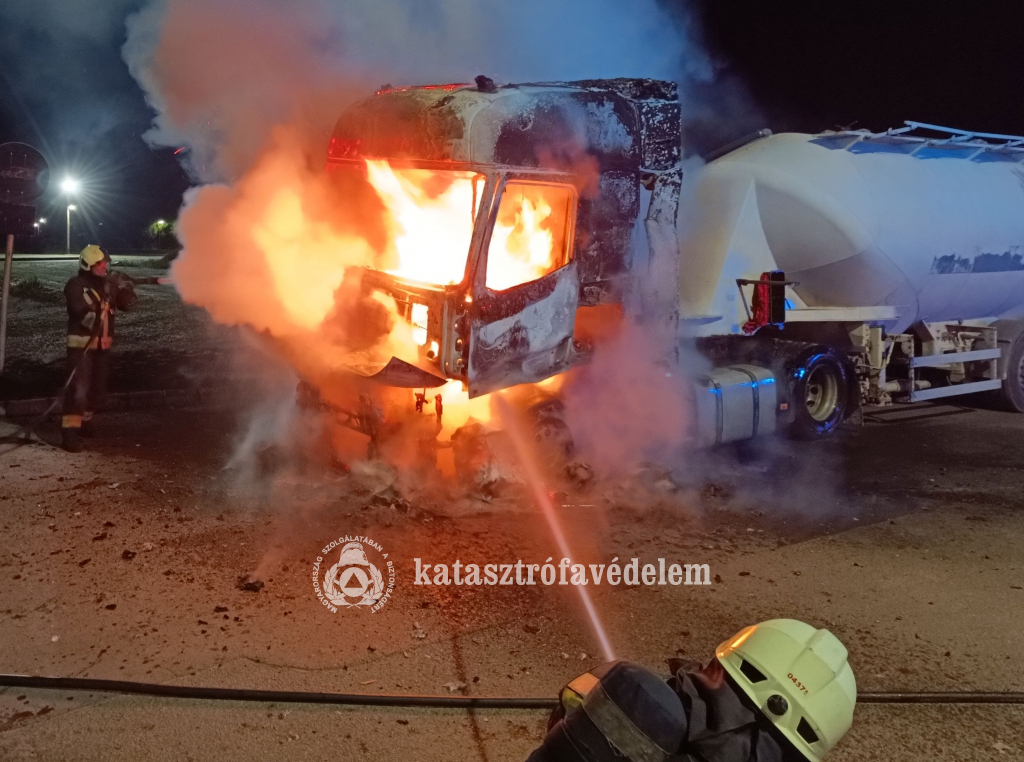 tűzoltók oltják a lángoló kamiont