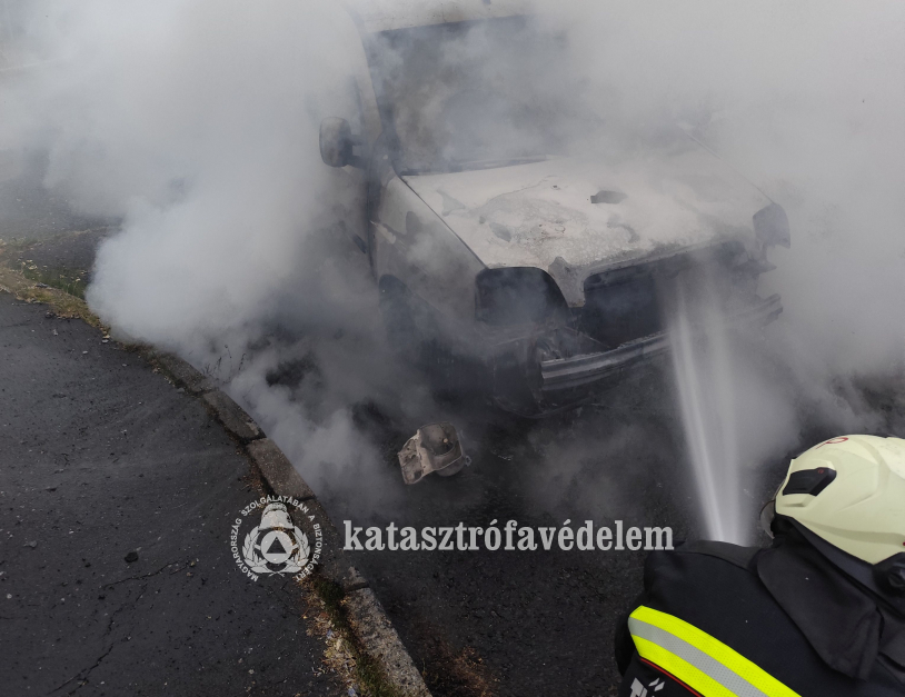 tűzoltó oltja az autót