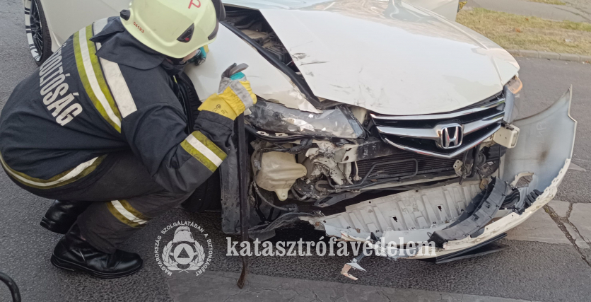 tűzoltó guggol az autó mellett