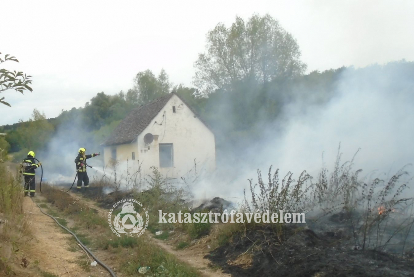 tűzoltók oltják a szabadtéri tüzet