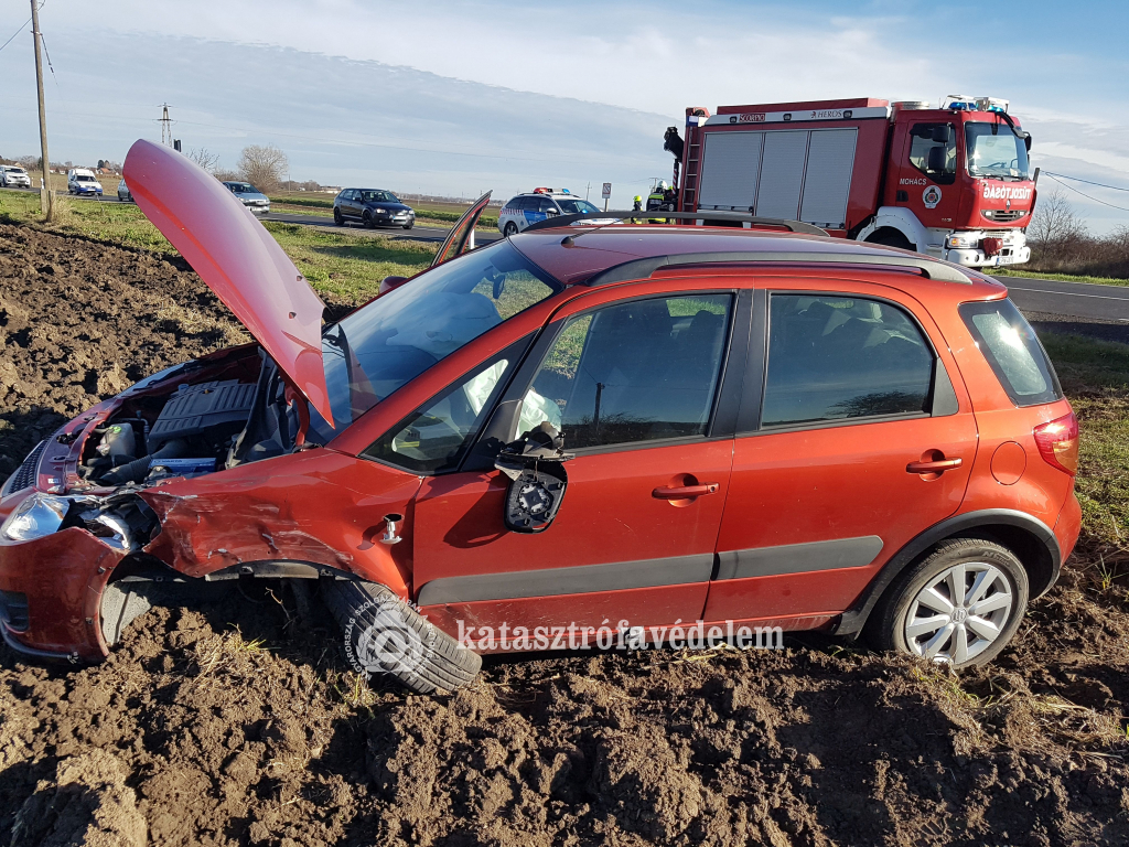 az autó kereke kitörött, a szántóföldön áll. háttérben tűzoltóautó